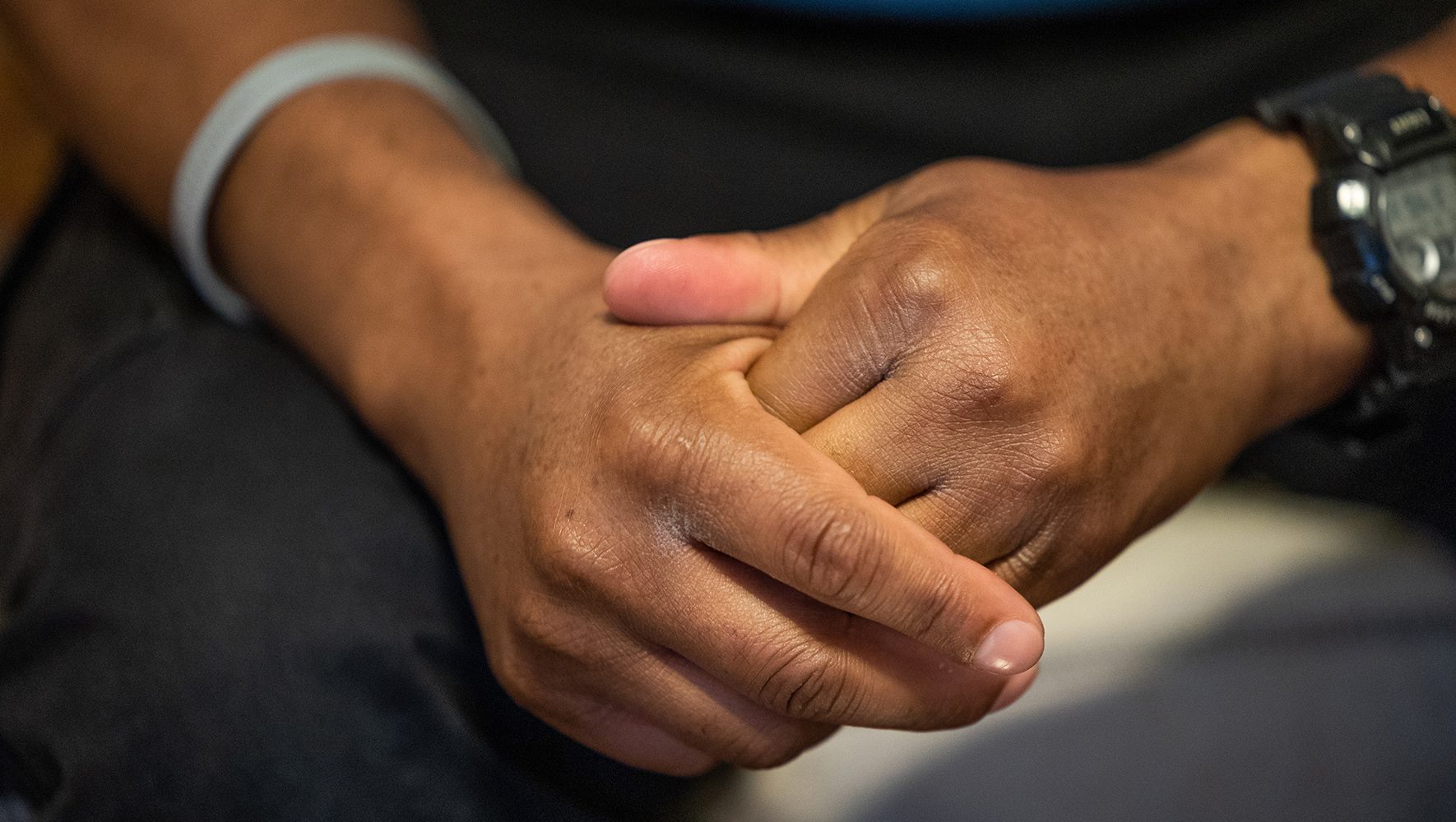 Robert's hands are seen as he recounts his escape from persecution under anti-LGBTQ laws in Uganda in his home near Philadelphia on June 12, 2023. | 