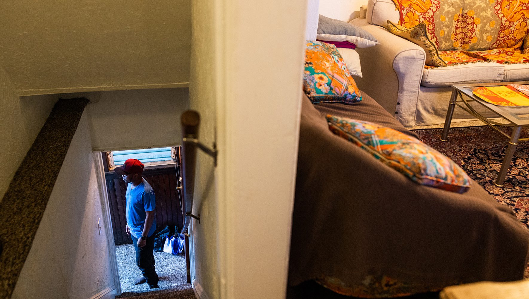 Robert stands in the staircase, looking out into his yard at his home near Philadelphia on June 12, 2023. | 