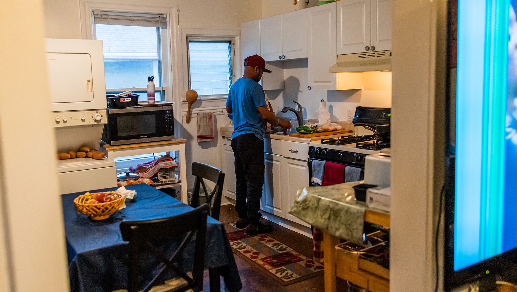 Robert cooks dinner at his home near Philadelphia on June 12, 2023. He enjoys cooking for himself and others; today, he prepares a meal of tilapia, mixed vegetables, and Katogo, a traditional Ugandan dish using green bananas. | 