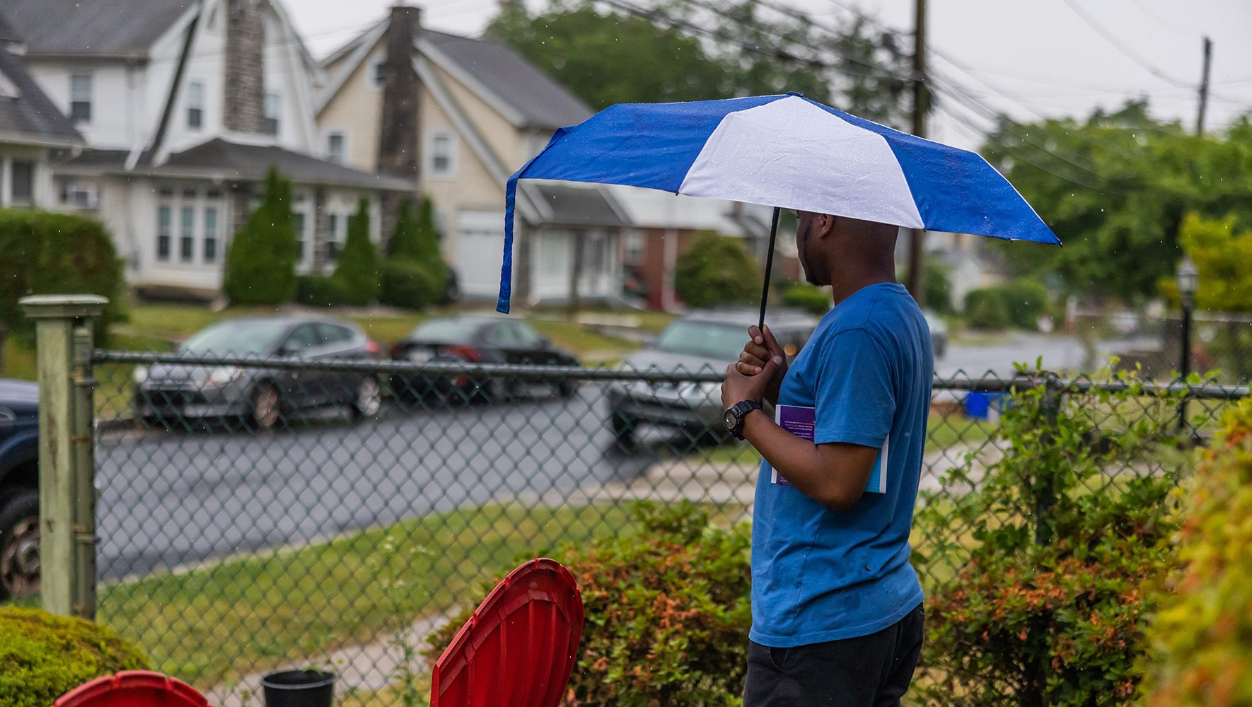 Robert, 36, a gay former refugee from Uganda, stands in his front yard near Philadelphia, Pennsylvania, during a lull in the rain on June 12, 2023. Robert was resettled by HIAS resettlement partner HIAS Pennsylvania in 2016. | 