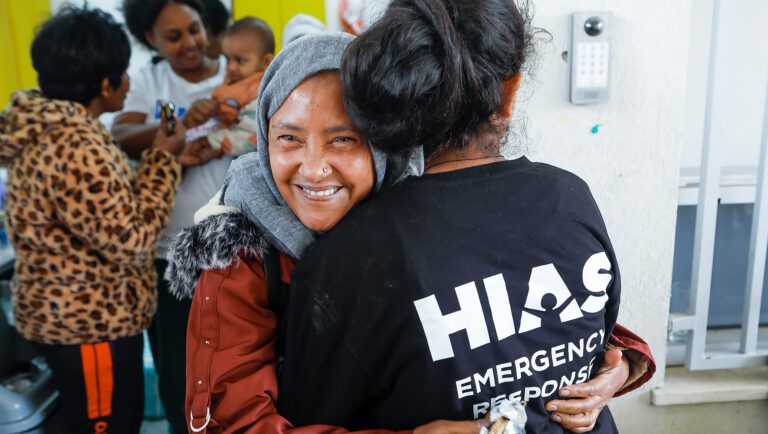 Semira, an African asylum seeker, embraces a HIAS volunteer during a food and supplies distribution in Tel Aviv, Israel, February 14, 2024. (AG for HIAS)