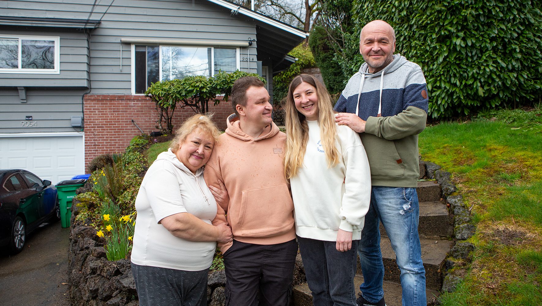 Standing outside their new home in Portland, Oregon are from left to right, Tamila Kushnarova, her son Eduard Levit, his wife Daria Levit and Tamila’s husband Oleksandr Kushnarov. After fleeing the fighting in their hometown of Kharkiv, Ukraine, the family was resettled with help from the ShalomPortland Welcome Circle. | Welcome Circles | HIAS
