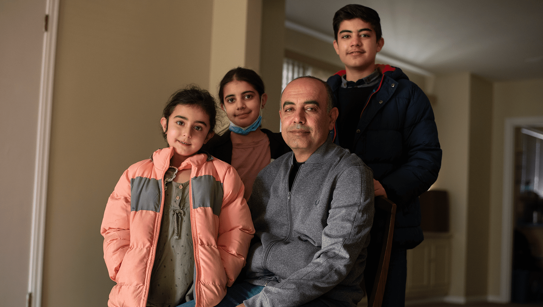 Afghan evacuee Zubair Babakarkhail sits with his three children in their new Pittsburgh apartment on Friday, Dec. 10, 2021. After being resettled by HIAS resettlement partner JFCS Pittsburgh, Babakarkhail now works for the organization as a cultural navigator. (Stephanie Strasburg/HIAS)