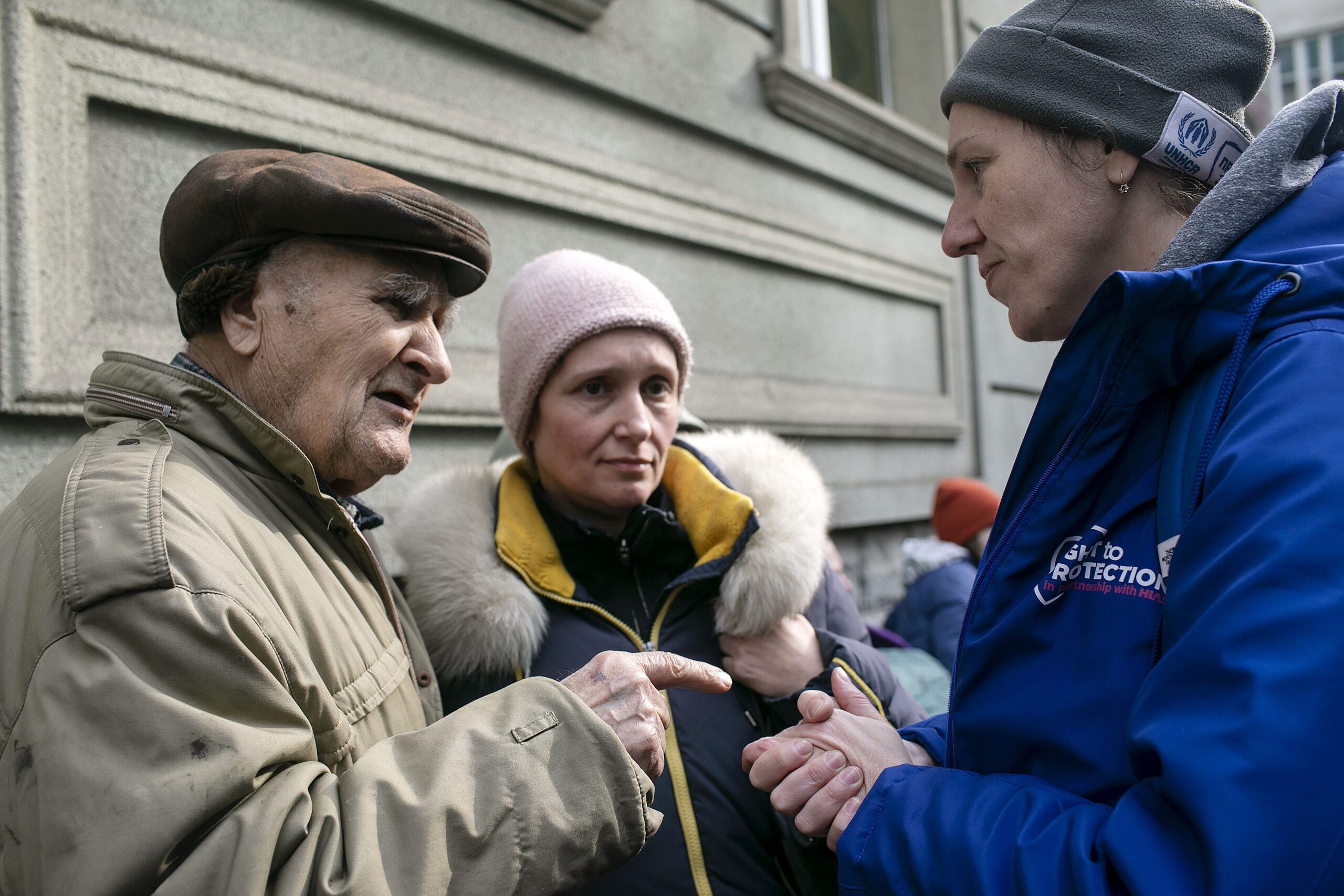 La coordinadora de R2P, Yulia Tralo (derecha), habla con Marianna (centro) y su padre de 84 años (izquierda) en la oficina de registro de refugiados de la ciudad de Lviv, Ucrania, el 30 de marzo de 2022. Huyeron de su hogar en Kharkiv Oblast hace dos semanas. Right to Protection (R2P) es una organización ucraniana de asistencia a refugiados creada con ayuda de HIAS en 2013. (AG para HIAS)