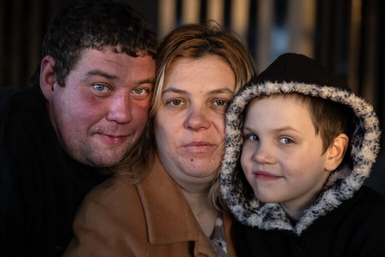 LVIV,UKRAINE - Oleg Razvadovsky poses with his partner Victoria Gura and their daughter Aryna, 9, inside the university shelter where they have lived since April 2022 after their home was destroyed in Ukraine's Donetsk district. The family is among many refugees in Lviv who have lost their homes due to the conflict in eastern Ukraine. Picture taken on February 12, 2023.