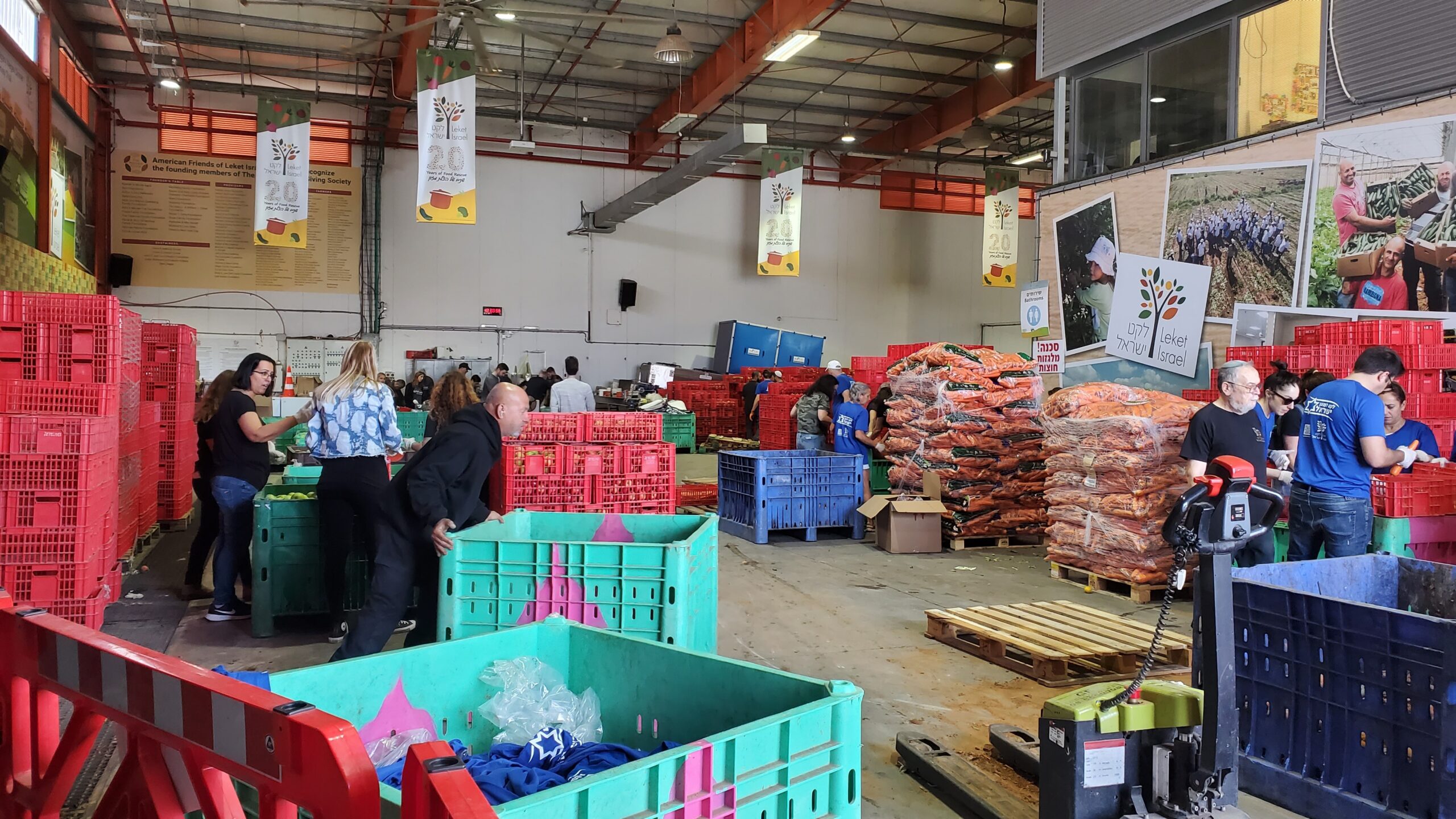 Brightly colored crates of food and people moving in a warehouse