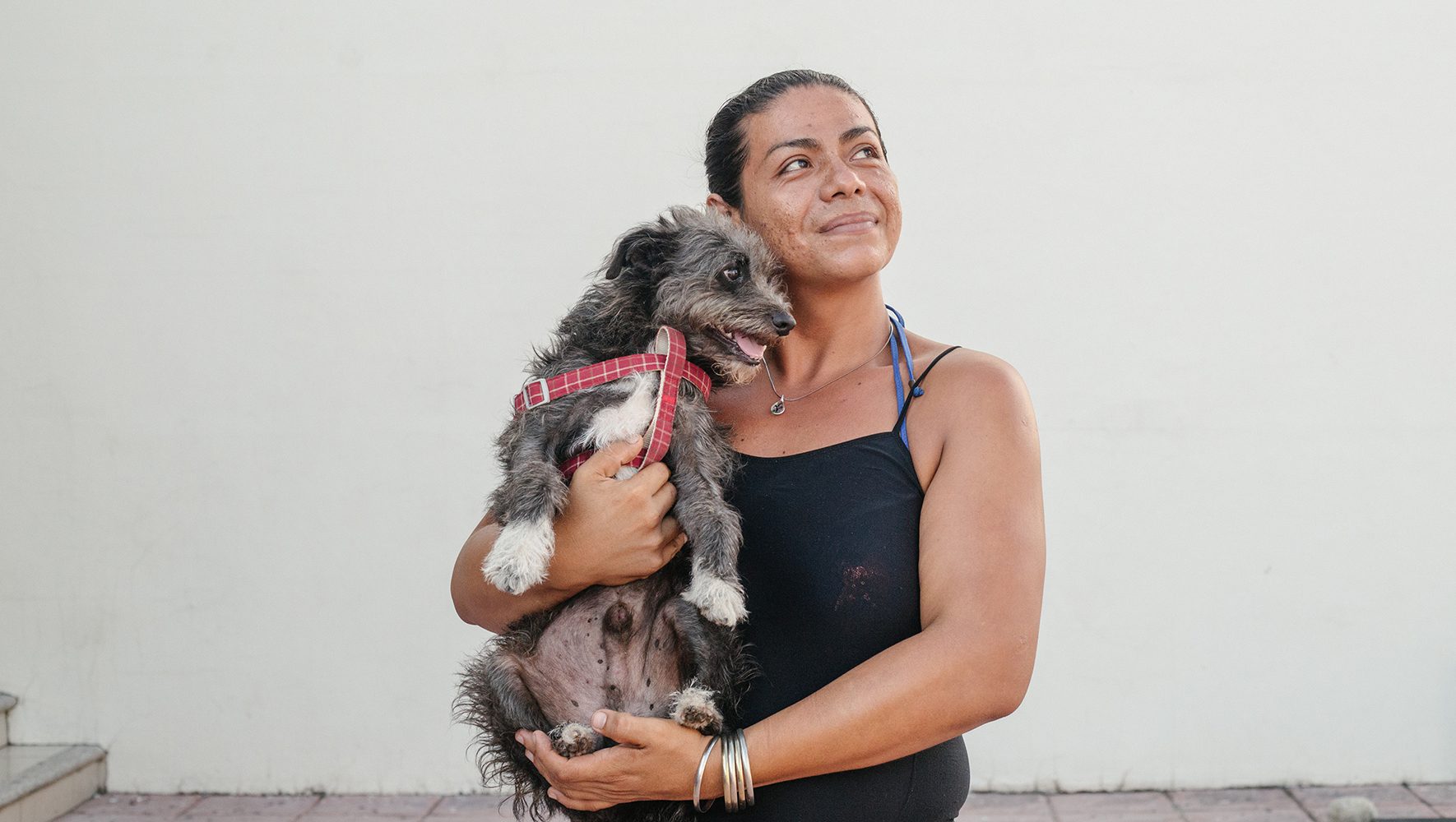 Evelin*, a transgender woman from Guatemala, poses for a photograph in Tapachula, Mexico, with her dog. September 12, 2023. (Seila Montes for HIAS)