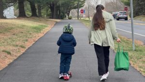 Una mujer y un niño pequeño caminan por una calle.