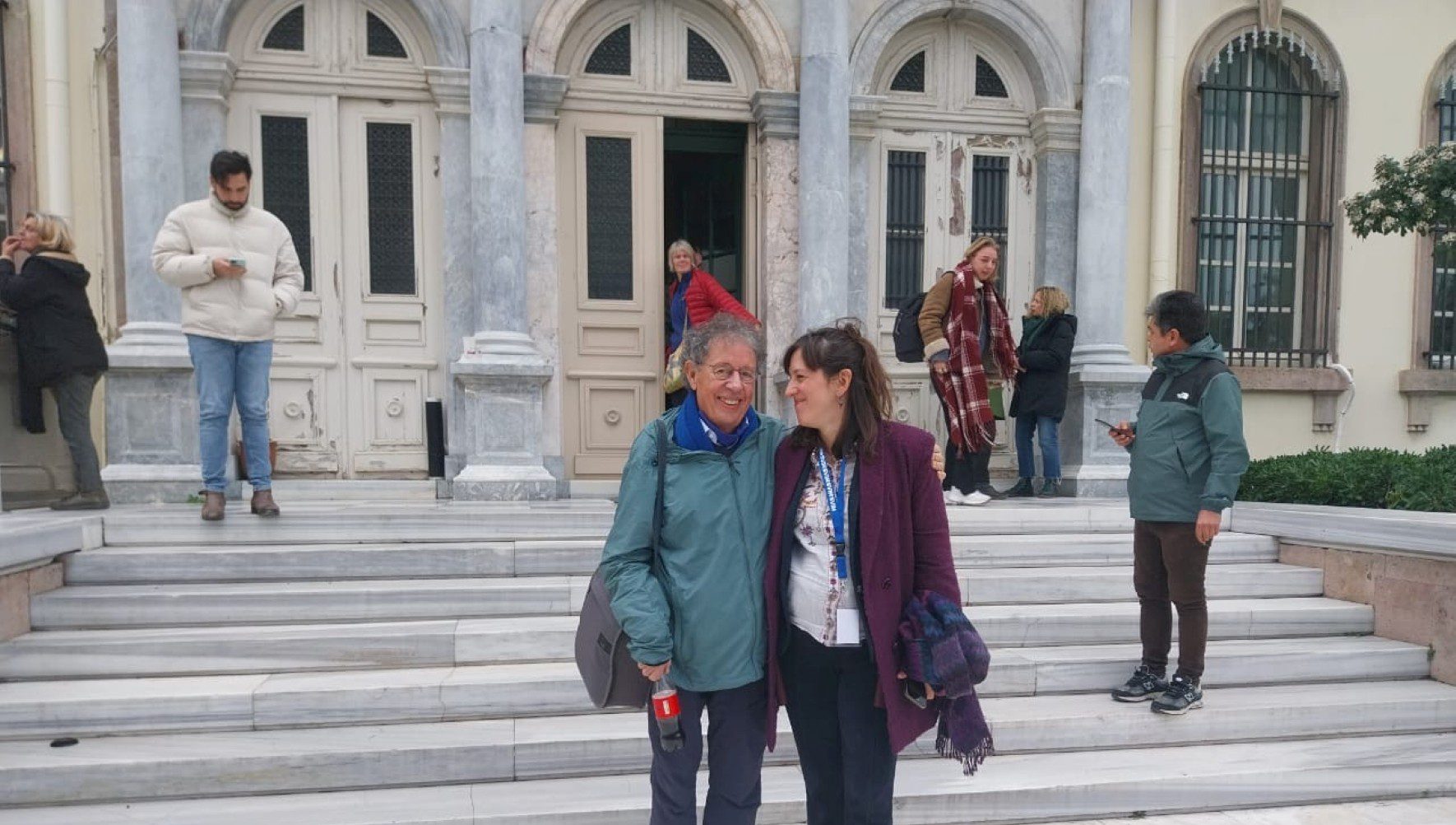 HIAS Greece client Pieter Wittenberg and Staff Attorney Maria Spiliotakara pose outside the courthouse in Lesvos during the proceedings of their case on January 15, 2026. Pieter and 23 other humanitarians were charged with human smuggling in 2018 for providing humanitarian assistance to asylum seekers in Greece. After eight years, they were acquitted on all charges. (HIAS Greece)