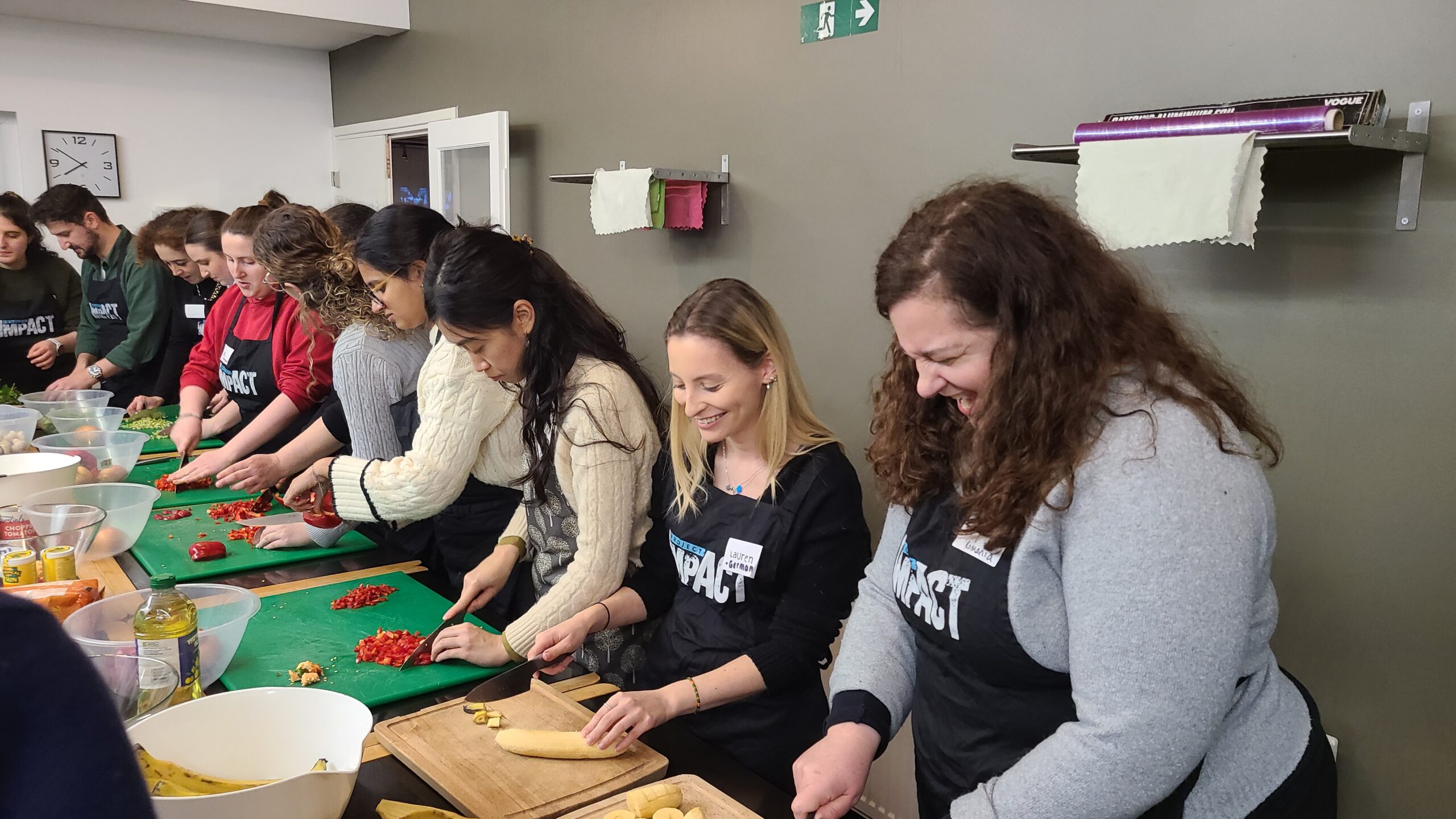 Refugee supporters, including Libi Sears (red sweater), join HIAS+JCORE and partner OLAM for a cooking event in honor of Refugee Shabbat in London on March 11, 2026. (Jennie van den Boogaard/HIAS)