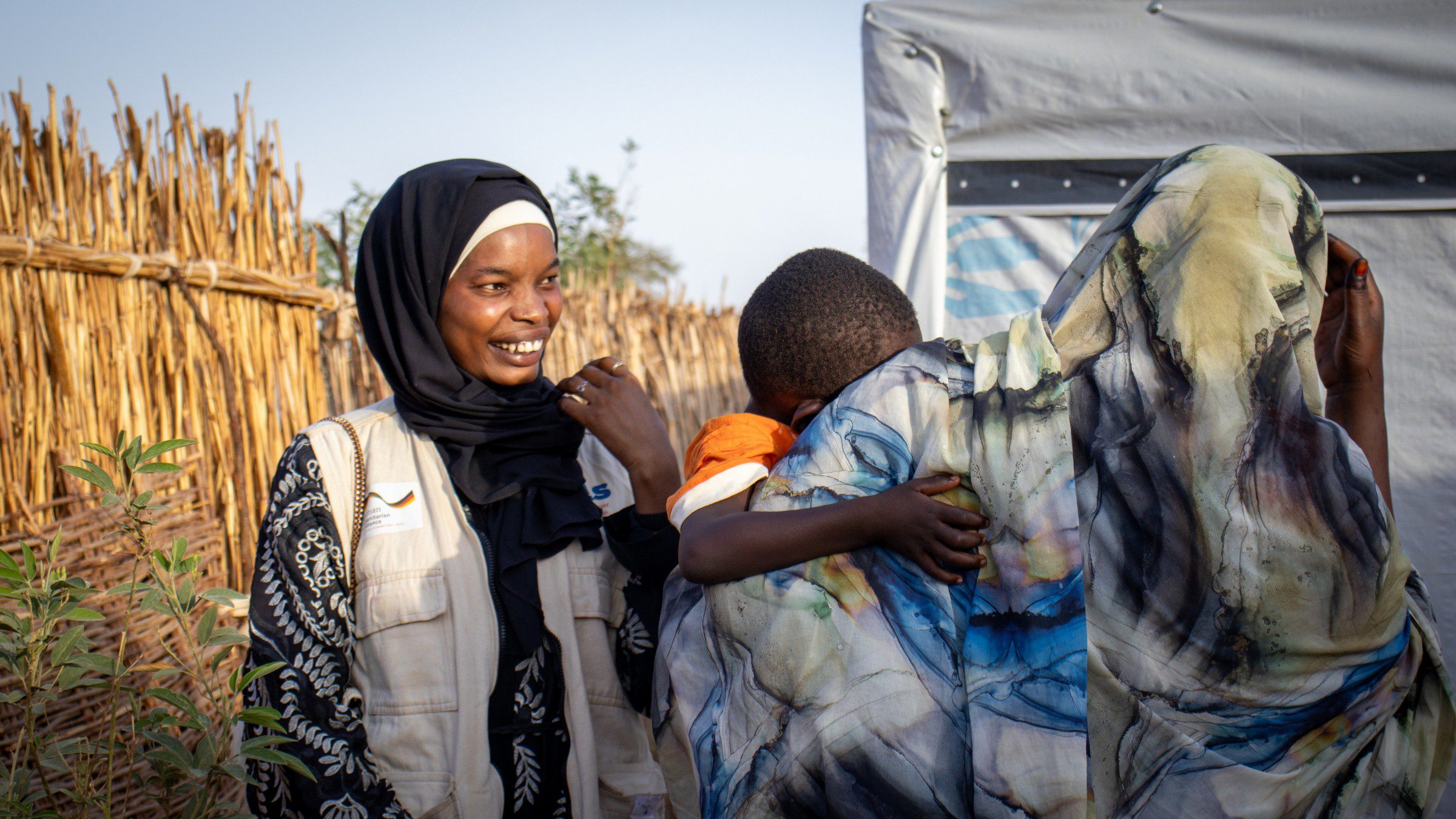 Higbal, a HIAS Chad staff member, speaks with Takwa, a program participant at the Farchana refugee camp, where HIAS Chad provides mental health care and protection services thanks to the support of HIAS Europe and GFFO, June 2026 (Saam Kouakaine for HIAS).