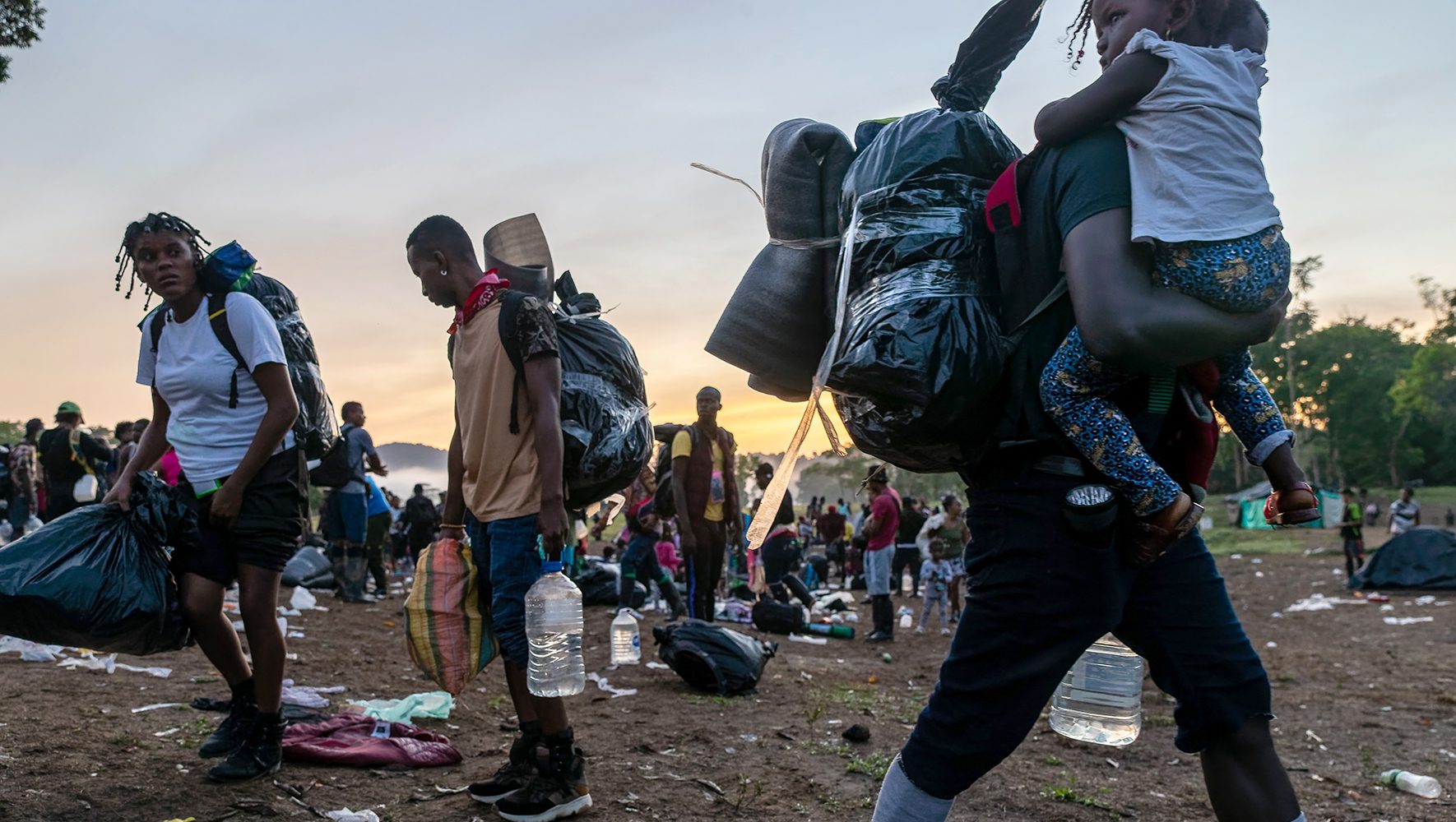 Migrantes, la mayoría procedentes de Haití, se preparan para salir de un campamento base hacia la infame Tapón del Darién durante su viaje hacia Estados Unidos el 07 de octubre de 2021 en Las Tekas, Colombia. | Más allá de la frontera: The Regional Effects of the U.S. Asylum Ban | HIAS