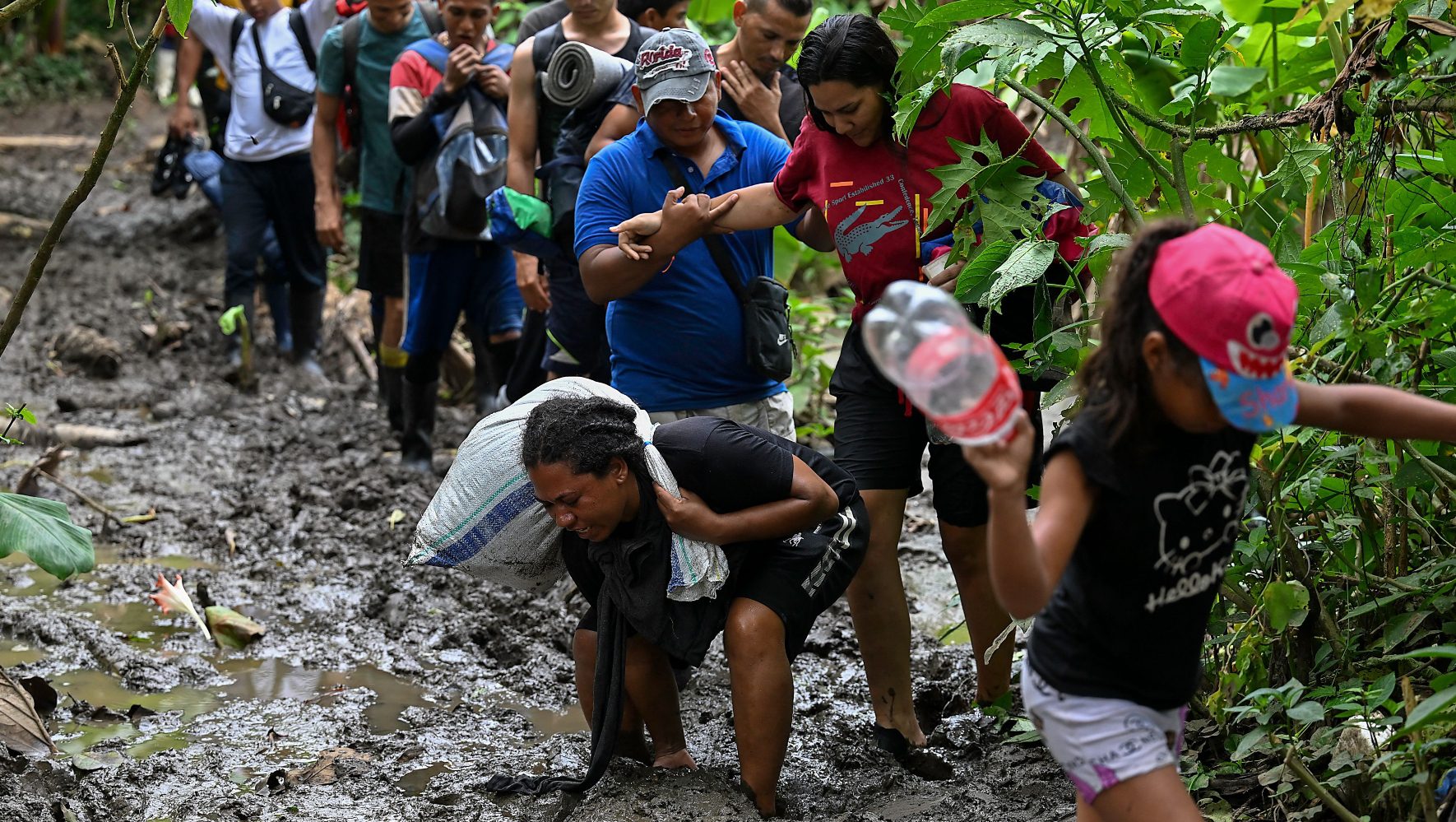 Migrants walk through the mud in the Darien Gap.