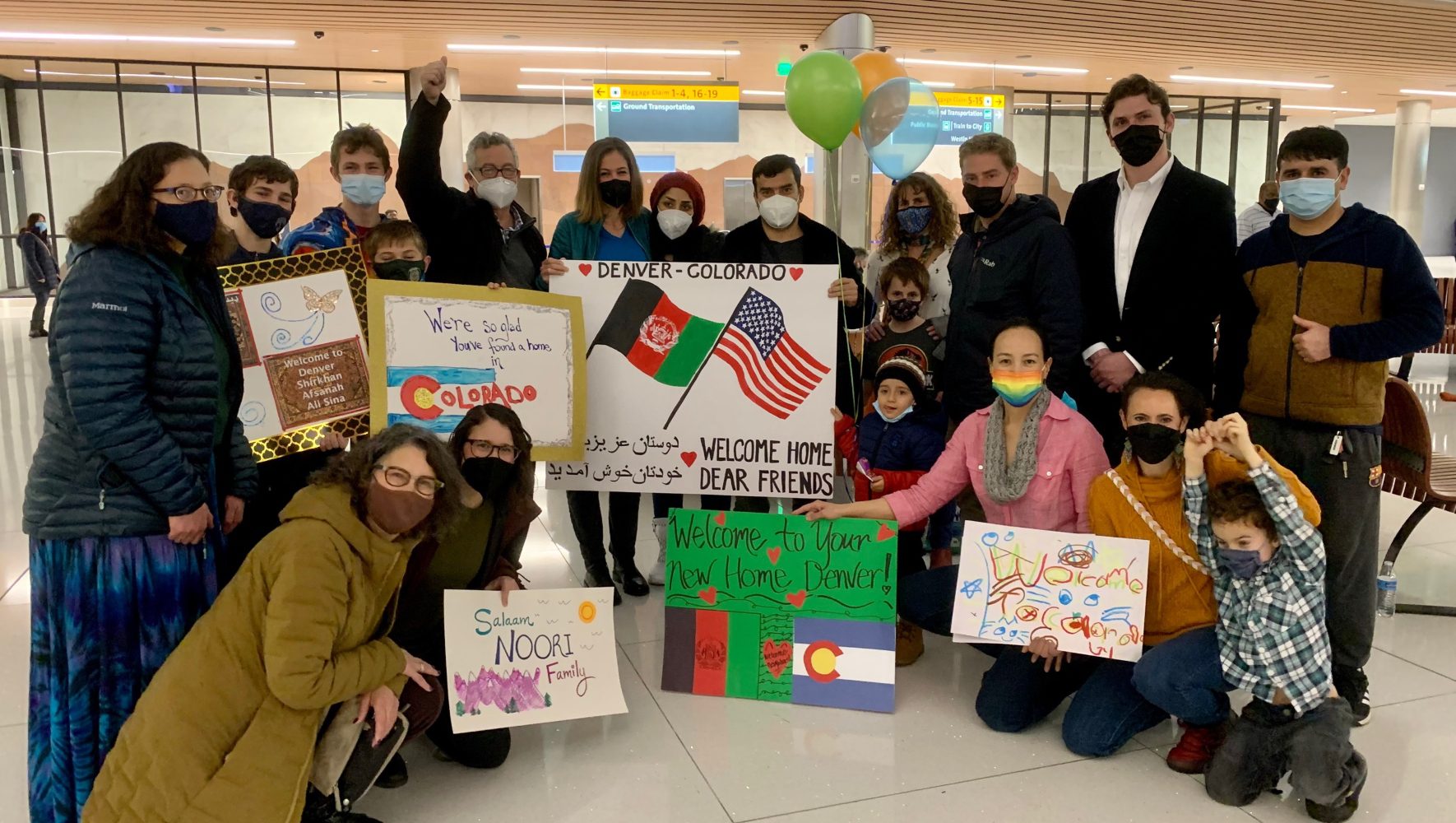 Un círculo de bienvenida recibe a una familia afgana en el aeropuerto de Denver, Colorado.