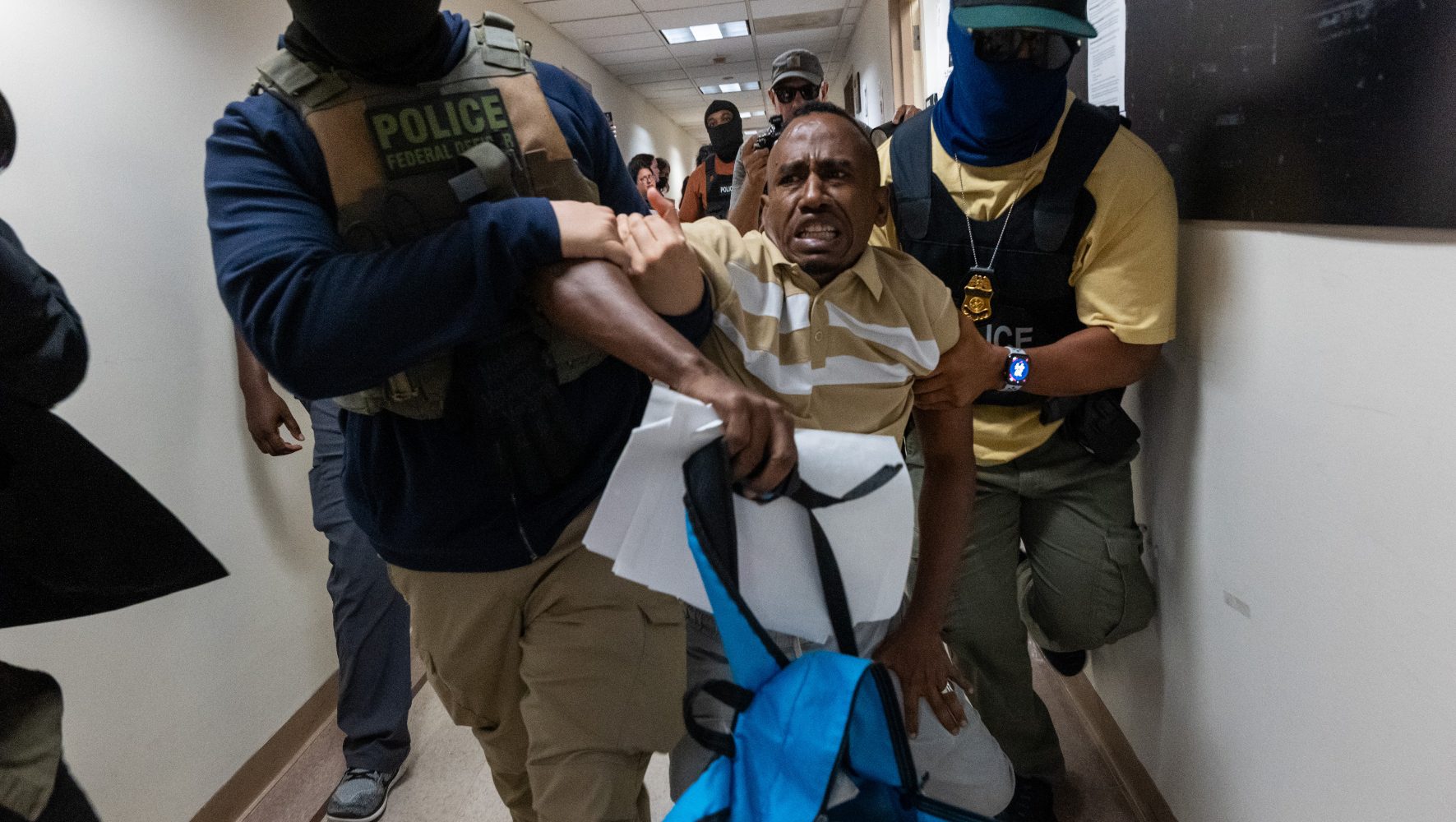 Federal agents, including members of ICE, drag a man away after his court hearing as they patrol the halls of immigration court at the Jacob K. Javitz Federal Building on July 24, 2025 in New York City.