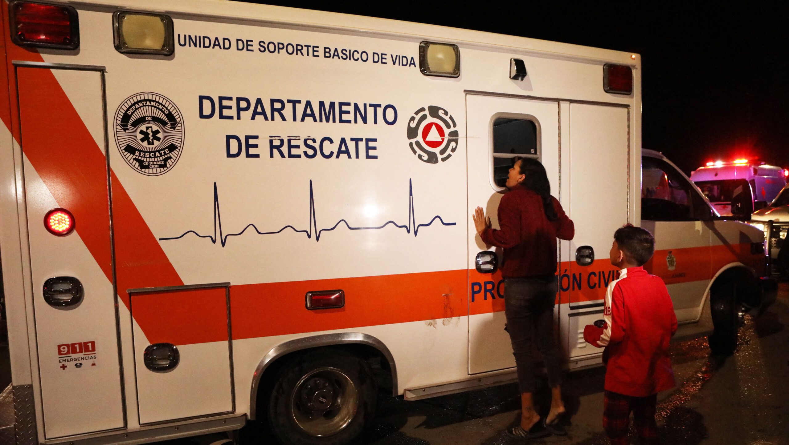 Woman cries next to an ambulance in which her husband, who was injured in a fire, is being transported following a fire at the immigration station in Ciudad Juarez, Mexico | Deadly Fire in Mexican Migrant Center