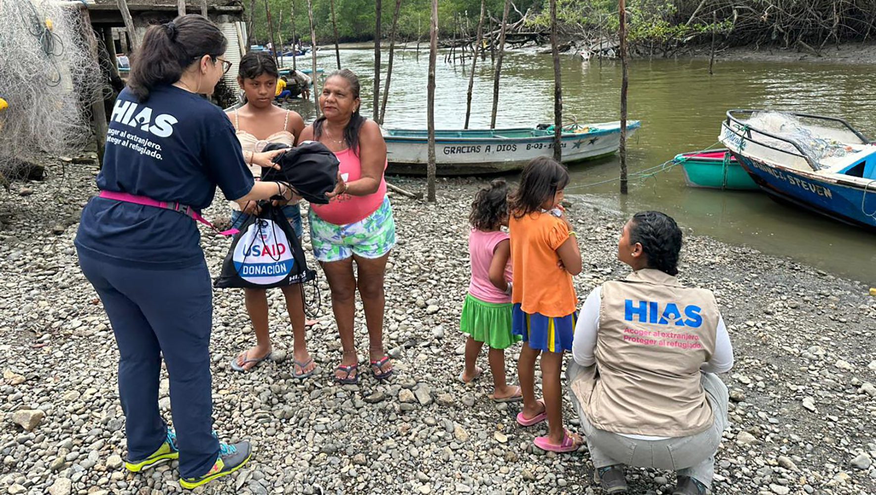 giving earthquake victims hygiene kits at water edge
