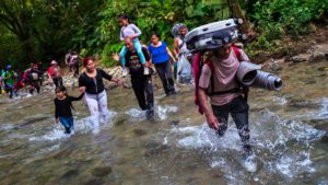Migrantes caminan por un río en la inhóspita selva tropical de Tapón del Darién, Colombia, 20 de noviembre de 2022. | Centro de Políticas para Refugiados } HIAS Centro de Políticas para Refugiados | HIAS