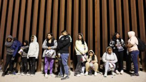Inmigrantes que buscan asilo en Estados Unidos esperan en fila mientras son procesados por agentes de la Patrulla Fronteriza de Estados Unidos en las primeras horas de la mañana después de cruzar a Arizona desde México el 10 de mayo de 2023 en Yuma, Arizona. | El fin del Título 42: Cinco puntos clave | HIAS