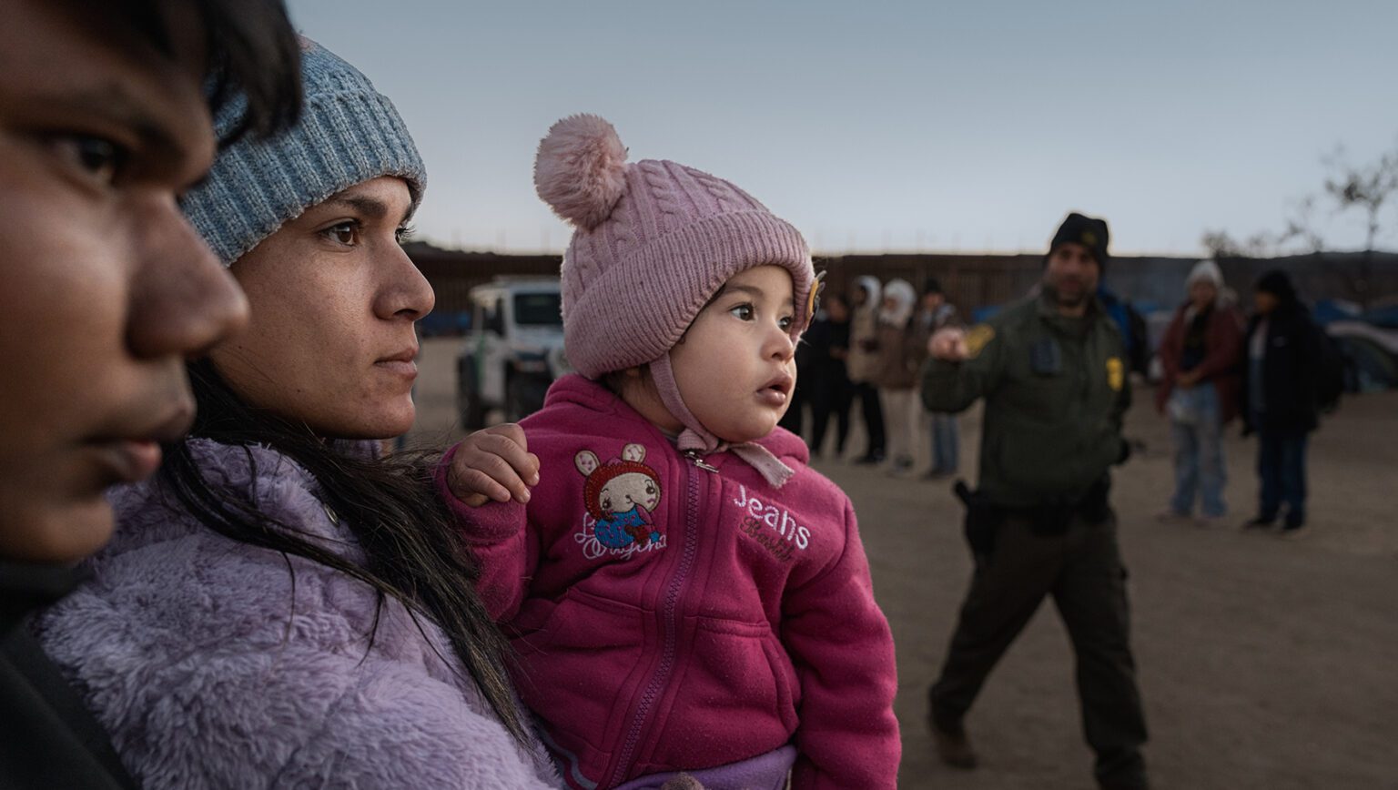 Asylum seekers wait to be processed by the U.S. Border Patrol after crossing from Mexico at a makeshift camp next to the U.S. border wall. | New Supplemental Funding Bill Would Trade Away Asylum Seekers' Rights | HIAS