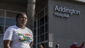 An activist of "March and March", an anti-immigration vigilante group, stands outside the Addington Hospital in Durban on July 4, 2025, during a demonstration in which members were checking for the nationality of those seeking to access the facility. The group worked to deny access to the hospital for anyone they didn't consider South African. (Photo by RAJESH JANTILAL/AFP via Getty Images)