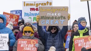 Community members hold banners as they show up to a press conference to demand accountability from Target after ICE agents were spotted staging at the parking lot in Minneapolis, Minnesota, U.S., on December 4, 2025. (Christopher Juhn/Anadolu via Getty Images)