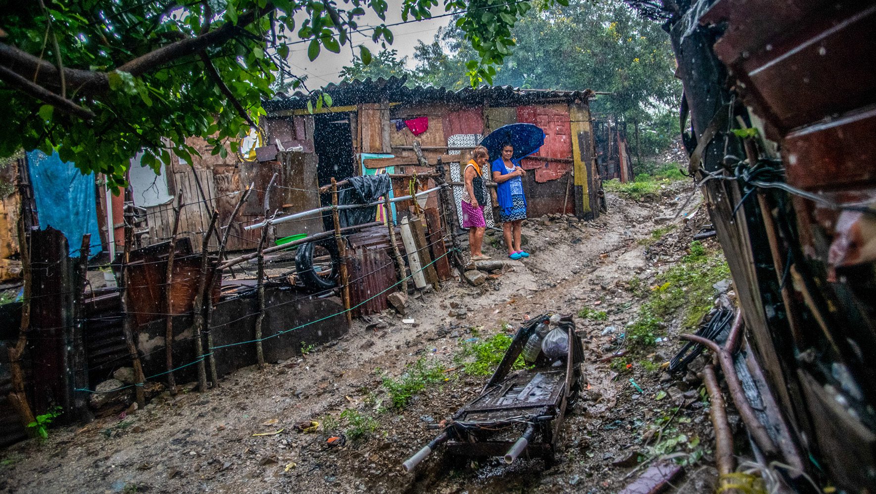 Two women stand outside their home while downpours from Hurricane Eta threaten to overflow the adjacent river and sweep their home away in San Pedro Sula, Honduras, November 5, 2020. (Seth Sidney Berry/SOPA Images/LightRocket via Getty Images)
