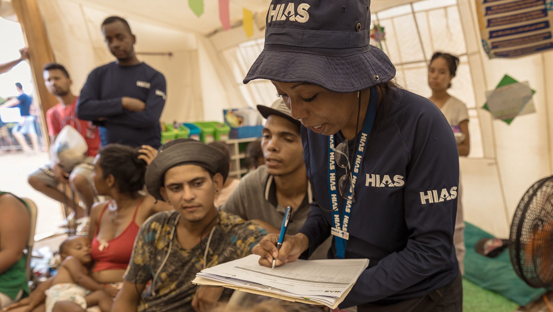 HIAS staff member Dilsa Sanchez gives personal supplies to migrants at the HIAS support tent in Migration Reception Center of Lajas Blancas, Panama. | In the Darien Gap, Refugees Find Help All Along the Way | HIAS