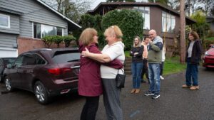 Arleen Zucker (izquierda) y Tamila Kushnarova comparten una sonrisa y un abrazo mientras se despiden tras una visita del Círculo de Bienvenida a la casa de Tamila. La casa aparece a la izquierda. | A tiempo para Pésaj, ucranianos encuentran comunidad judía en EE.UU. | HIAS