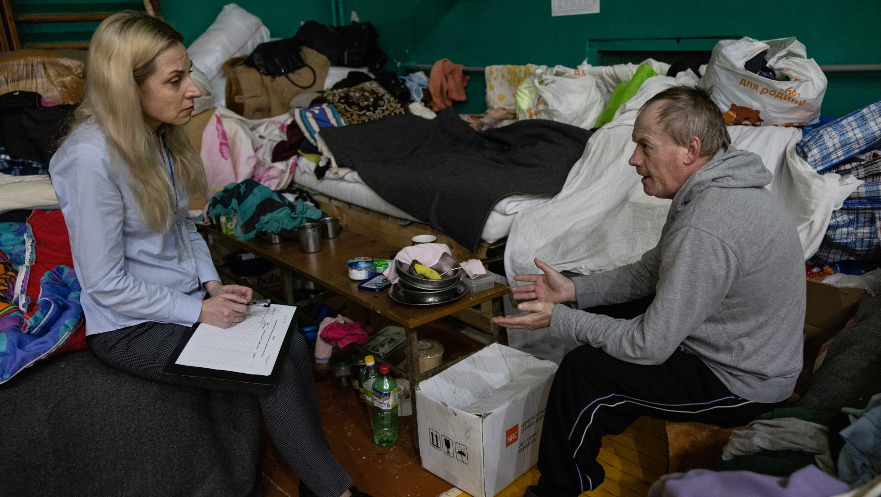 Olena Leshkovich, an associate in mental health and psychosocial services at HIAS Ukraine, speaks with Oleg Gaduchka at a shelter in Lviv, Ukraine, on February 8, 2023. Gaduchka is an internally displaced person who fled Bakhmut, in eastern Ukraine. (Paula Bronstein for HIAS)