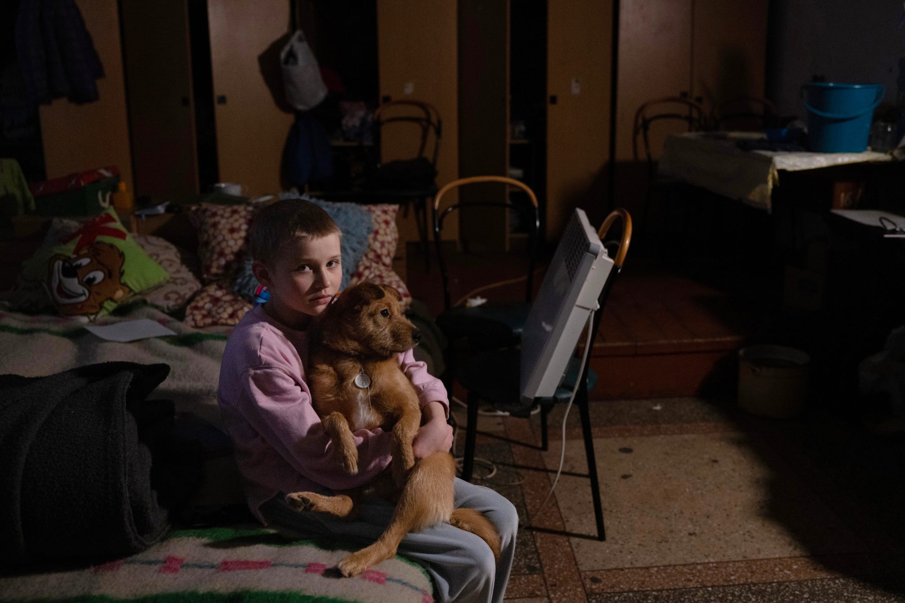 A small boy and dog reside at a shelter in Lviv, Ukraine.